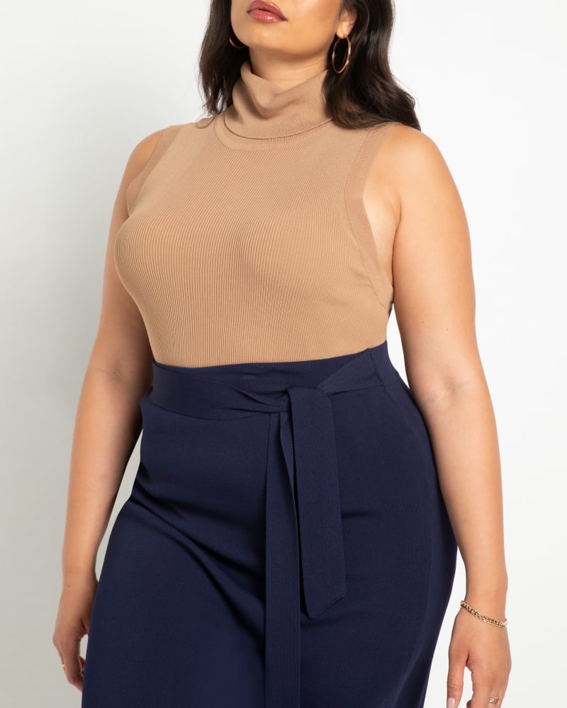 Front of a model wearing a size 14/16 Iris Turtleneck Layering Sweater in Burro by ELOQUII. | dia_product_style_image_id:241937
